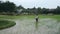 Spraying with pesticides, an unidentified Vietnamese farmer walks through field.