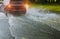 Spraying water of a car moving driving car on flooded road during flood caused by torrential rains. Cars float on water, flooding