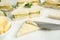 Spreading butter on tasty sandwiches with cucumber and parsley on white marble table, closeup