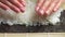 Spreading Cooked Sushi Rice On A Seaweed Wrap - Sushi Making - close up, slow motion.Sushi Chef Spreading Japanese Sushi