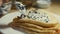 Spreading lump fish black roe with taramasalata on blinis. Isolated closeup macro