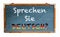 â€œSprechen Sie Deutsch?â€ in German language, Do you speak German? written on a wide blue old grungy vintage wooden chalkboard