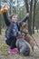 In the spring afternoon in the forest  a girl trains two French bulldogs