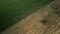 Spring agricultural land. A plowed and cultivated field borders on an uncultivated area overgrown with grass. Aerial photography