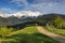 Spring alpine landscape with green fields and high snowy mountains,Bran,Transylvania