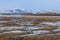 Spring arctic landscape. View of the tundra, colorful buildings and mountains.