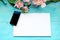 Spring background a blue wooden background with flowers blackboard and mobile phone