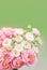 Spring background with flowers. Bouquet with bush roses on a soft green background . Pink and cream roses in a wedding bouquet