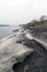 Spring Bank of the river with the remains of dirty melting snow on cloudy day