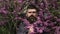 Spring bearded man with blossom flovers, outdoor portrait. Brutal bearded man brunette with elegant mustache near the