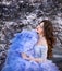 Spring Beautiful romantic haired girl in blue lace dress standing in blooming garden with owl.