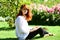 Spring Beautiful romantic red haired girl in blooming garden. Tenderness Young model in spring park. Red head female