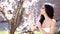 Spring beauty. Woman with blooming tree. Springtime girl outdoor.