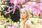 Spring bloom concept. Girl on dreamy face, tender blonde near violet flowers of judas tree, nature background. Lady