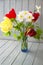 Spring bouquet with red and yellow tulips and narcissus. Fresh flowers. Colorful bouquet of fresh spring flowers on blue