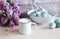 Spring breakfast still life scene. Mug with milk, branch of lilac, Easter eggs on the linen tablecloth. Easter food and