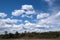 Spring cloudscape with sun on white clouds and blue sky