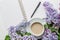 Spring composition flat lay white cup of coffee, violet beautiful bouquet of lilacs, notebook, pen, concept of spring