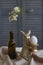 Spring composition, golden rabbit figurine with egg on beige tablecloth and vase with flowering twig, Easter concept, selective