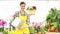 Spring concept, smiling woman florist with flowers basket and watering can
