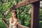 Spring country portrait of adorable dreamy kid girl near wooden fence with teddy bear