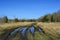 Spring countryside landscape with puddle on muddy road