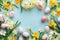Spring daffodils and tulips with Easter eggs on pastel blue background