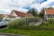 Spring day in the village. Small vegetable garden with beds and first plantings. Wooden houses, villas, cottages with tiled roofs