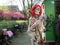 Spring fairy, skeleton dressed up with red wig, glasses and sword on the streets of Amsterdam