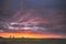 Spring Field In Evening Sunset. Natural Bright Dramatic Sky Pink Magenta Purple Colours Above Countryside Meadow