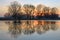 Spring flood on sunset with reflection of trees in river