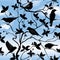 Spring floral seamless wallpaper with birds on branches over blue sky