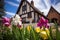 spring flowers blooming in front of a tudor gable