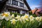 spring flowers blooming in front of a tudor gable