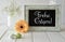 Spring flowers, Easter decorations and a blackboard on white table, text