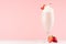 Spring fresh pink milkshake with strawberry and whipped cream on soft pink background, copy space.