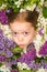 Spring funny girl outdoors portrait in blooming trees. Teenager girl with bouquet of purple and white lilac.