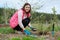 Spring gardening, female gardener working in gloves with garden tools fertilizes the soil with mineral granulated fertilizers