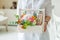 Spring gift set in hands of woman. Macaroons and flowers.