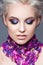 Spring girl with trendy make up smoky eyes . Short clarified hairs, with violet petals of a tulip on her neck