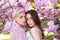 Spring girls fashion. Beautiful young woman enjoying flowering garden. Girlfriends couple.