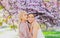 Spring girls in flowers. Outdoor portrait of young beautiful happy smiling female couple posing near flowering tree.
