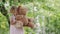 Spring and happy summer time. Joyful smiling little girl playing with teddy bear swinging on the swing, child with blue eyes and