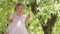 Spring and happy summer time. Joyful smiling little girl swinging on the swing, child with blue eyes and curly blond hair plays in