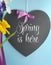 Spring Is Here greeting on heart shape blackboard