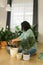 Spring hobby happy young woman transplanting in flower pot houseplant with dirt or soil at home. Gardening plant and