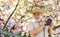 Spring holidays. Travel photo. Retirement travel. Capturing beauty. Photographer in blooming garden. Senior man hold