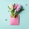 Spring hyacinth flowers in pink postal envelope over blue background with copy space. Top view, flat lay. Square crop. Spring,