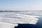 The spring ice drift on the river Volga. Road bridge in the city of Saratov. Russia. A Sunny day in March. Blue sky