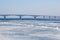 The spring ice drift on the river Volga. Road bridge in the city of Saratov. Russia. A Sunny day in March. Blue sky